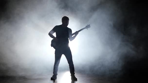 Чоловік грає на бас-гітарі і стрибає на музику — стокове відео