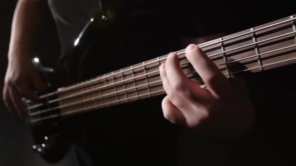 Primer plano. Dolor y cuerda bajo eléctrico guitarra. Movimiento lento — Vídeo de stock