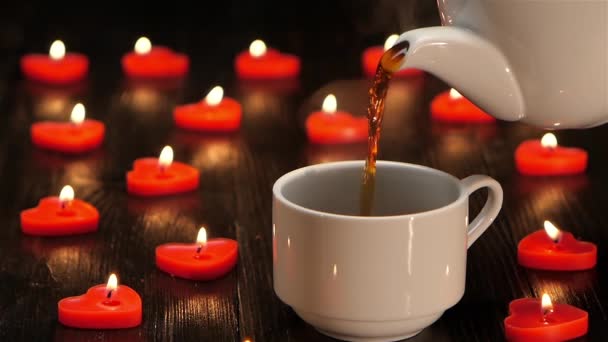 Bílý hrnek s horkou kávou na pozadí hořících svíček — Stock video