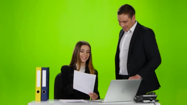 Сотрудники офиса смеются над увиденной ошибкой в документе — стоковое видео