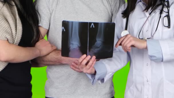 Kvinna läkare visar en patient röntgen bild av hans fötter — Stockvideo
