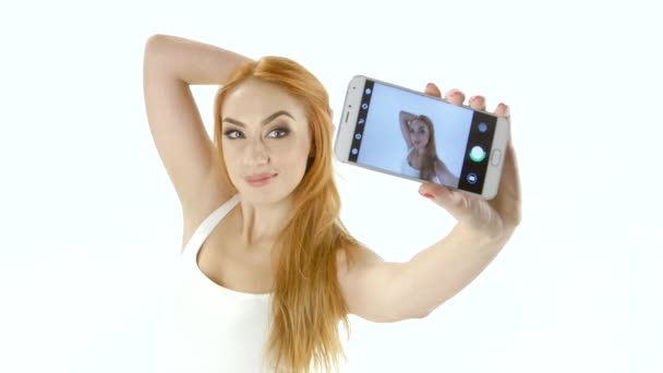 Cute redhead girl doing selfie on your smartphone. White background — Stock Video