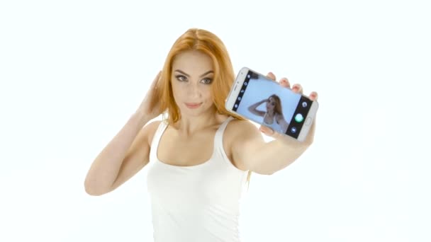 Pelirroja modelo chica haciendo selfie en su teléfono inteligente. Estudio blanco — Vídeos de Stock