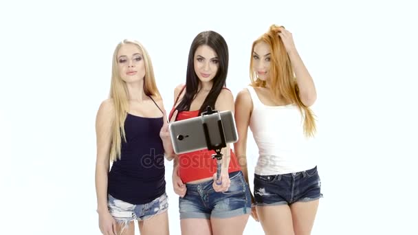 Три девушки позируют для селфи. Белый фон — стоковое видео