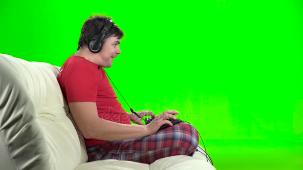 Gamer τους παίζοντας παιχνίδια στον υπολογιστή που κάθεται στον καναπέ. Πράσινη οθόνη — Αρχείο Βίντεο