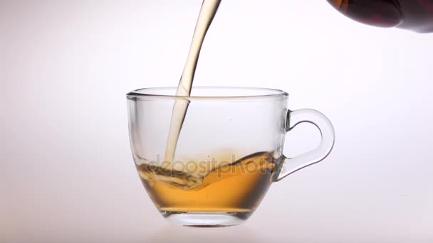 El té se vierte de una tetera en una pequeña taza de vidrio — Vídeos de Stock