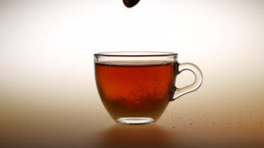 Şeker küçük bir fincan sıcak çay içinde karıştırın. Stüdyo