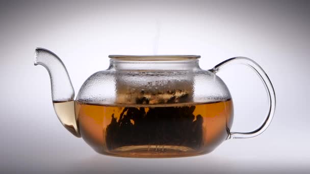 Le thé est infusé dans une théière en verre. Au ralenti. Studio 