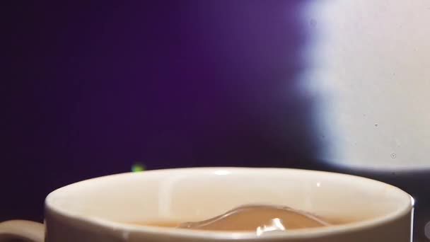 W filiżance kawy z mlekiem spada kawałek cukru. Zbliżenie — Wideo stockowe