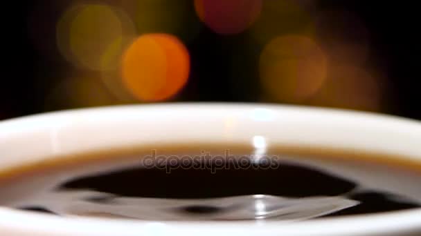 Primer plano. Gota de leche en el café negro caliente — Vídeos de Stock