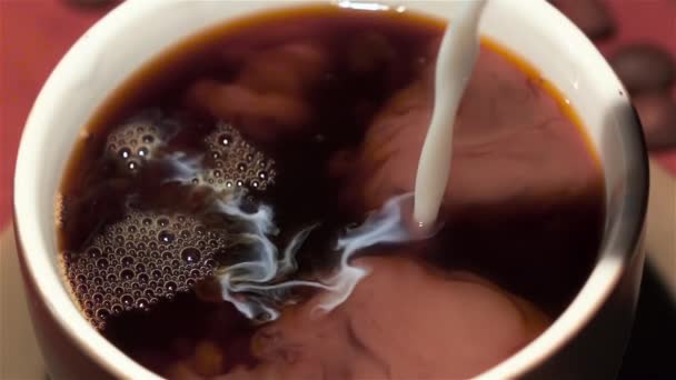 Le lait est ajouté dans une tasse de café noir. Gros plan 