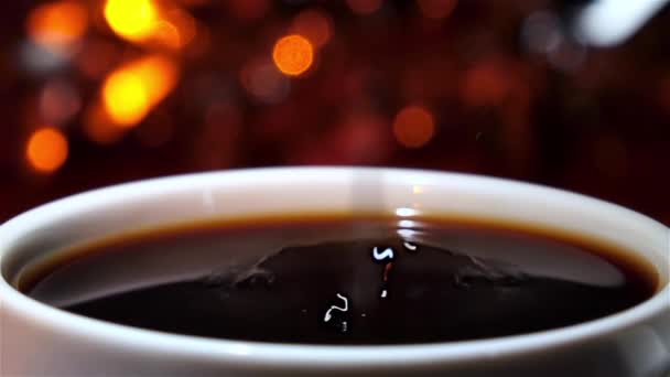 Ein Tropfen Milch fällt in eine Tasse heißen Kaffee — Stockvideo