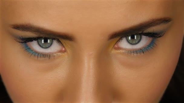 Meisje met een mooie lichte make-up en scherpe ogen kijken aandachtig. Close-up — Stockvideo