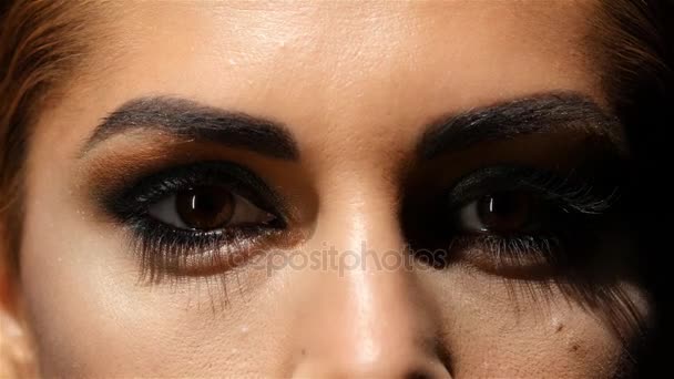 Chica con maquillaje, cremas para la cara se componen y hermosos ojos marrones. De cerca. — Vídeos de Stock