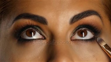 Visagiste bir fırça ile çalışmalarını ayarlar. Ağır çekim. Yakın çekim