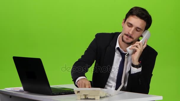 Мужчина звонит домой в конце рабочего дня из офиса — стоковое видео