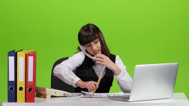 Una mujer distraída por el trabajo una llamada telefónica, toma notas. Estudio — Vídeo de stock