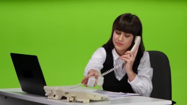 Büroangestellte telefonieren mit zwei Telefonen gleichzeitig. Studio — Stockvideo