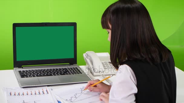 Computer portatile a schermo verde su una donna che lavora alla scrivania. Studio. — Video Stock