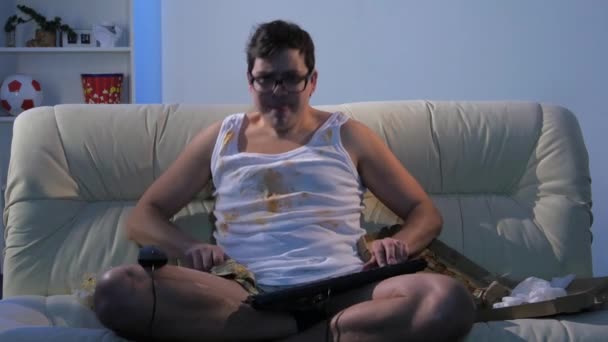 Gamer sentado en el sofá y jugando juegos en la red — Vídeos de Stock