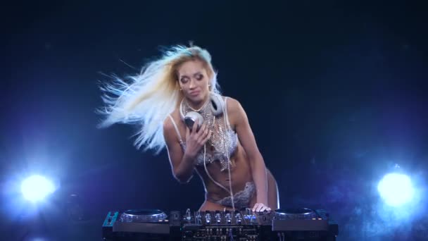 DJ de pelo largo rubia mujer gira vinilo y juega con el pelo — Vídeos de Stock
