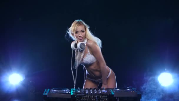 Sexy blonde girl DJ twists vinyl and her buttocks. Studio — Stock Video