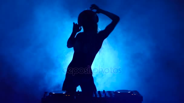 Silhouette di ragazza DJ nel fumo mescola musica — Video Stock