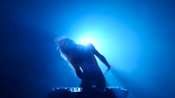 Білявка дівчина DJ грає трек і еротично танцює — стокове відео
