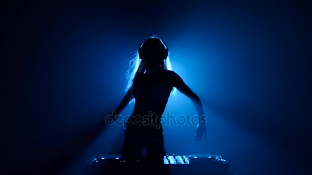 Silhouette of sexy longhair woman dj dancing behind the decks — Stock Video