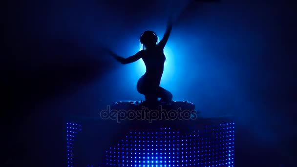 Silhueta de sexy DJ menina dançando atrás dos conveses — Vídeo de Stock