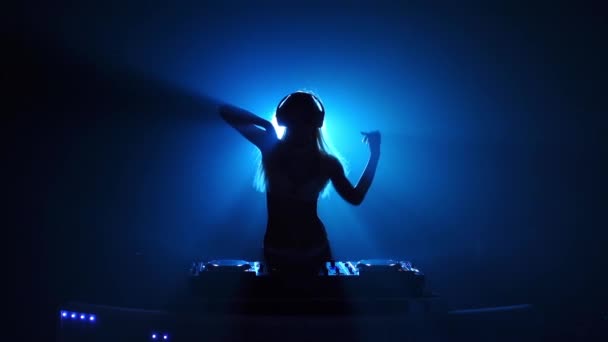 Silhouette eines sexy DJ-Mädchens, das hinter den Decks tanzt — Stockvideo