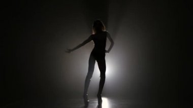 Studio koyu arka plan üzerinde poz kadın silüeti