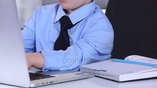 Liten pojke affärsman tittar på bärbar dator och tangentbord att skriva tabeller — Stockvideo