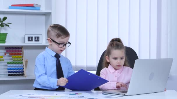 Los niños se imprimen en el portátil y ver gráficos de la carpeta azul — Vídeo de stock