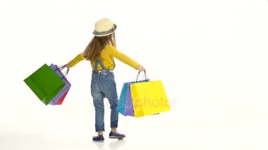 Küçük kız ellerinde paketlerle whirl etrafında. Beyaz arka plan. Ağır çekim