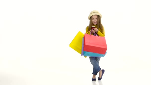 Chica en un sombrero con paquete de teléfono y postes de pishit. Fondo blanco. Movimiento lento — Vídeo de stock