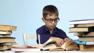 Tablo ve heyecanla kitap sayfaları leafing çocuk oturur. Mavi arka plan.