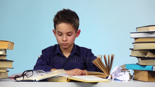疲倦的男孩开始关闭和折叠书。蓝色背景 — 图库视频影像