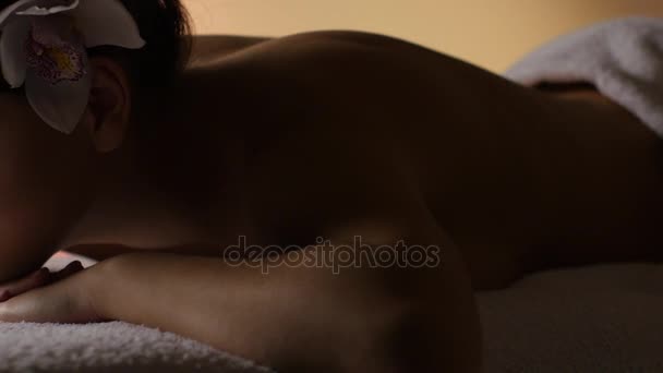 Meisje rust na een massage in het schemerige licht. Studio — Stockvideo