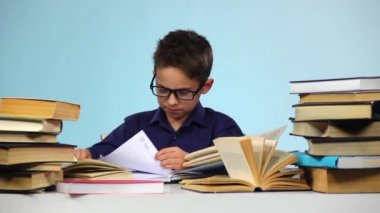 Küçük çocuk kitapları yaprak çeker. Mavi arka plan. Ağır çekim