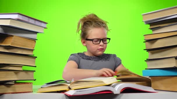 Menina sentada à mesa e nervosamente joga livro. Tela verde — Vídeo de Stock