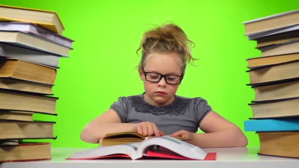 A rapariga lê o livro fecha-o e leva outro. Tela verde. Movimento lento — Vídeo de Stock