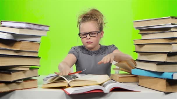 Menina sentada à mesa e nervosamente joga livro. Tela verde. Movimento lento — Vídeo de Stock