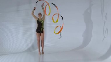 Onun elinde bir kurdele ile incelikle dans ritmik jimnastikçi. Beyaz arka plan