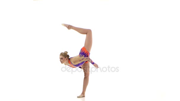 Gymnastka v pěkný oblek se točí míč na prst. Bílé pozadí — Stock video