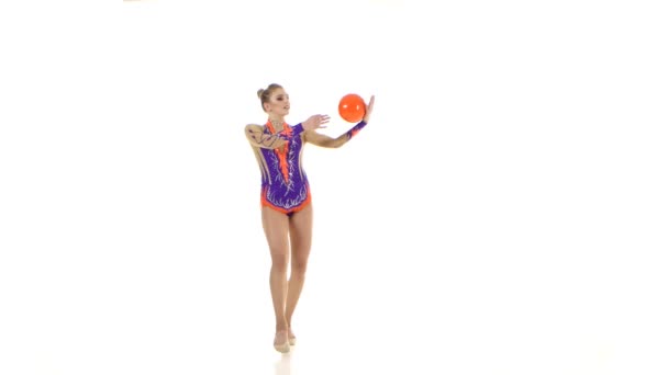 Gymnaste flexible conduit la balle sur son corps. Fond blanc — Video