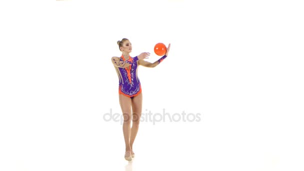 Gymnaste flexible conduit la balle sur son corps. Fond blanc 