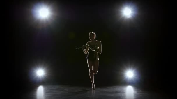 Gymnaste fille avec une masse à la main tournent autour de lui. Fond noir. Arrière léger — Video