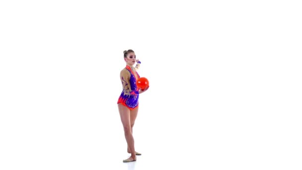 Gymnastka kruh kolem sebe na jedné noze. Bílé pozadí. Zpomalený pohyb — Stock video