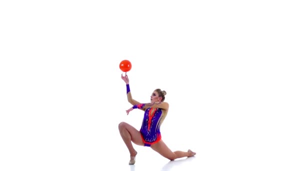 Gymnaste flexible conduit la balle sur son corps. Fond blanc. Mouvement lent — Video